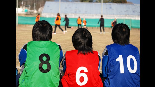 Supportive team mates watch their peers play with the U.S. Women’s National Team.