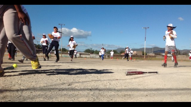 After a fun game of softball with the sports envoys, a team of teenage girls trot off the field.