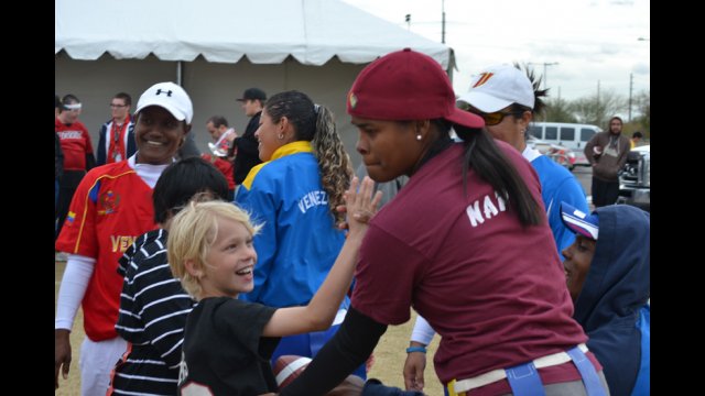 The young coach visitor high-fives a young American emerging athlete. 