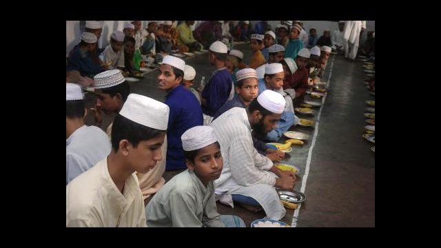 Young men gather in a madrassa for the evening meal called Iftar to break their fast durning the month of Ramadan. Kala Chandpur, Dhaka