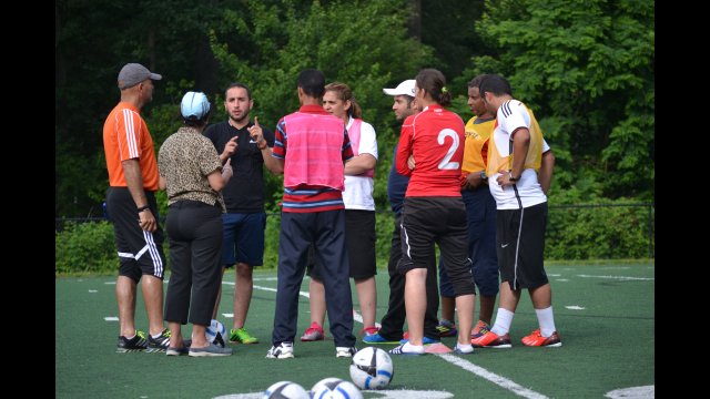 The coaches come together to get an explanation of new drills and conditioning methods they could implement with their athletes back home.