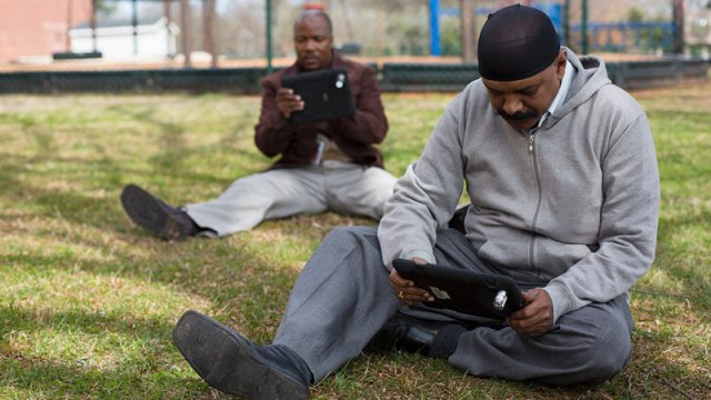 Photo of TEA participants Joseph Mamogo, of South Africa, and Kumar Mariyanna, of India, record their magnified surroundings on iPads, using an inexpensive mini-microscope,  in a demonstration of how to cost-effectively incorporate technology into lessons