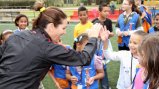 Julie Foudy provides positive encouragement to a girl for scoring a goal. Julie Foudy provides positive encouragement to a girl for scoring a goal.