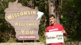 Participant holding sign that says Pakistan to Wisconsin USA