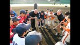 Cal Ripken huddles with young baseball players. 