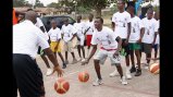 Former NBA Player Bo Outlaw dribbles with a teenager from Congo Brazzaville.