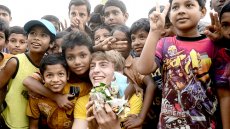 Filip posing with Bangladeshi children whle picking up garbage.