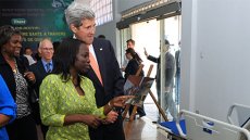 Patricia Nzolantima explains to U.S. Secretary of State John Kerry how she provided microfinance assistance to women so they could start medical supply stores like the one he toured in Kinshasa on May 3, 2014.