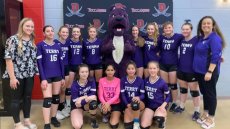 Jeremy dressed as a purple dog team mascot with the team 