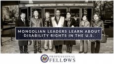 Group of 7 pose in front of a transit station entrance with title graphic on top