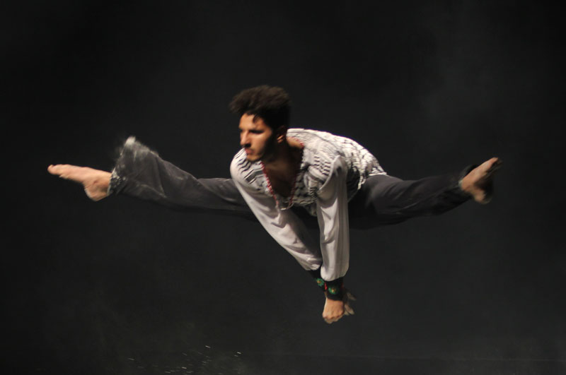 Young man in high jump with legs extended wide