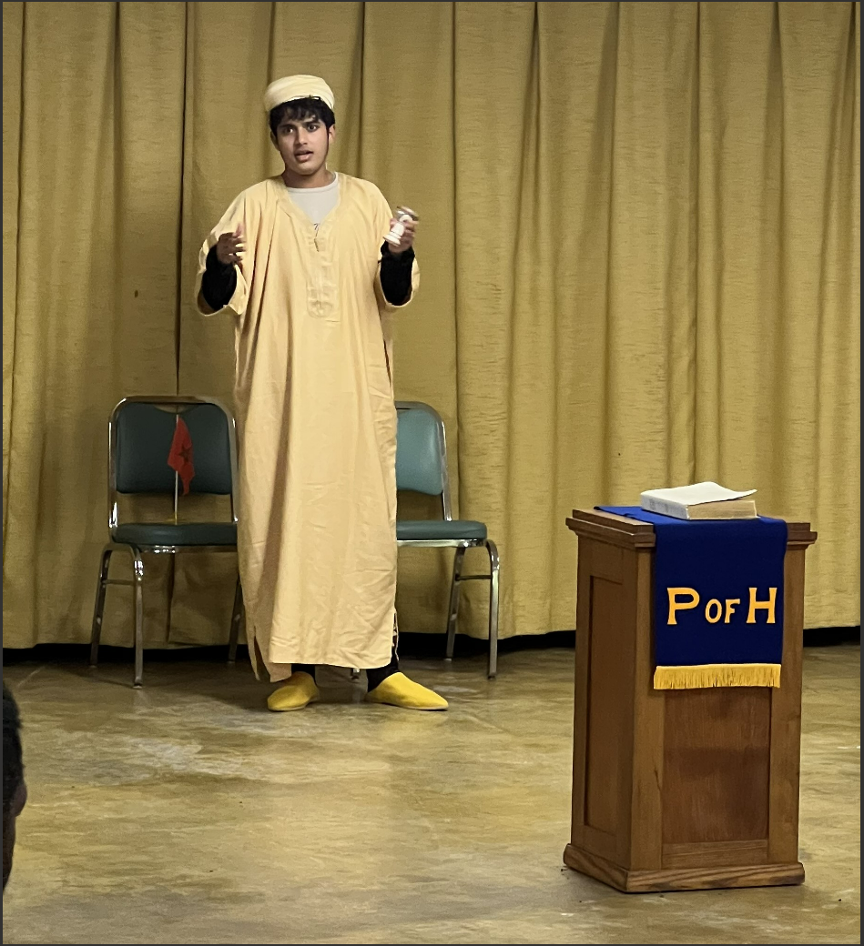 Youssef dressed in traditional moroccan clothes giving an iew presentation